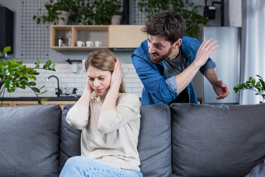 Domestic violence. Family conflict. A man shouts at a woman at home.